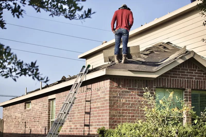 Professional roofer working on a residential roof in Hallsville